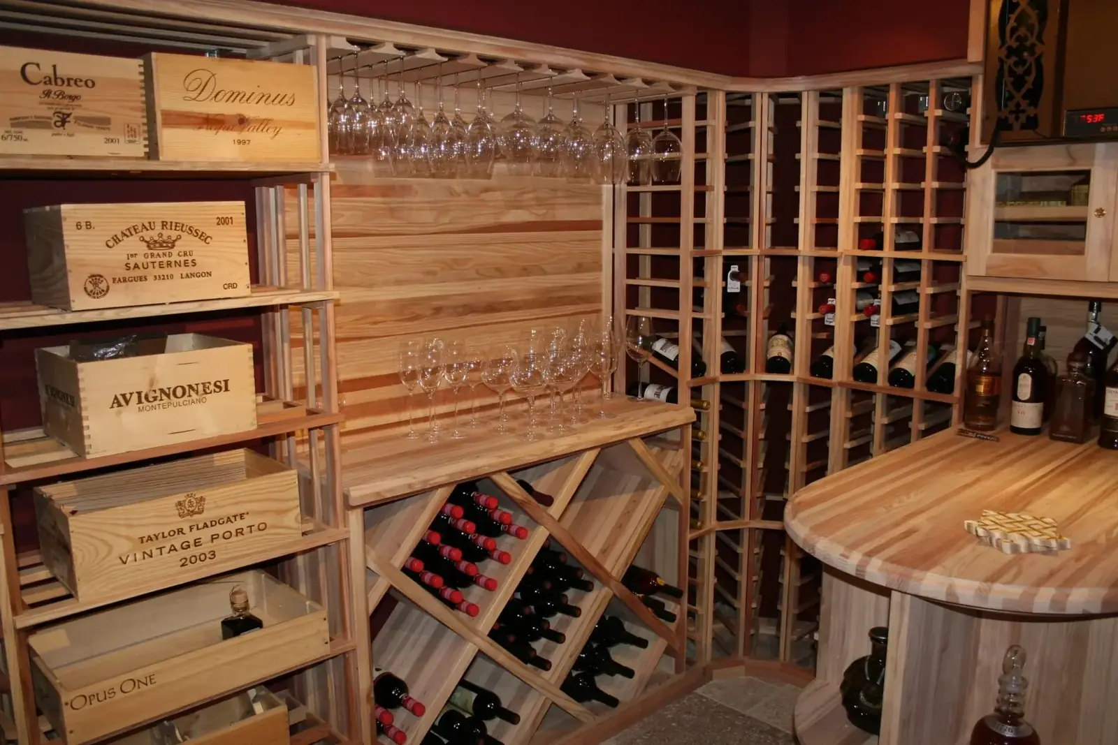 Custom Charlottesville wine cellar with cedar racking, integrated stemware storage, butcher-block tasting counter, and low-profile architectural speakers